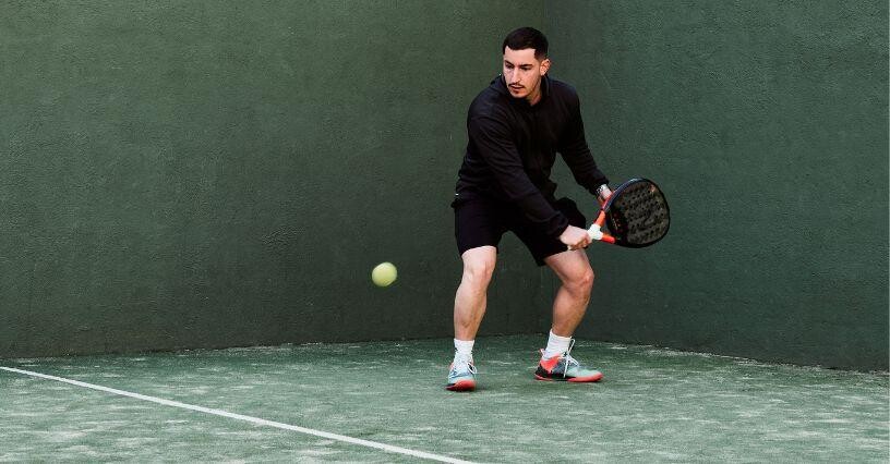 Ein Mann spielt Padel-Tennis auf einem Platz